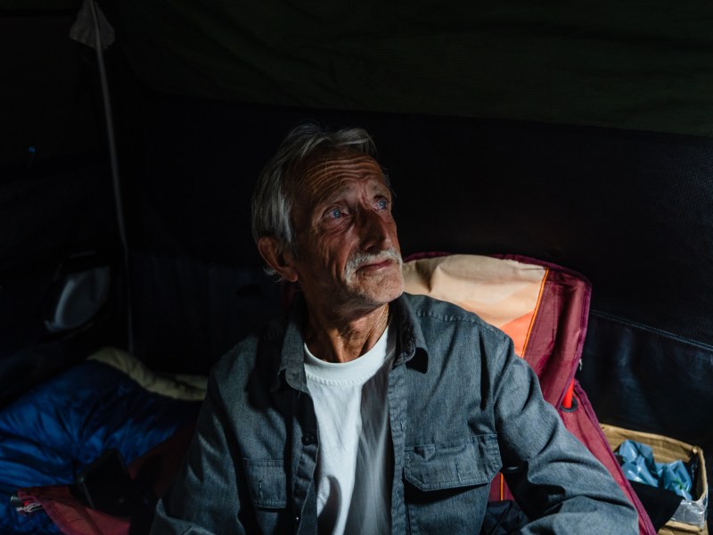 TW, 68 years old from Maine sits in his tent at a homeless encampment on Commercial Street in downtown on March 30, 2023.